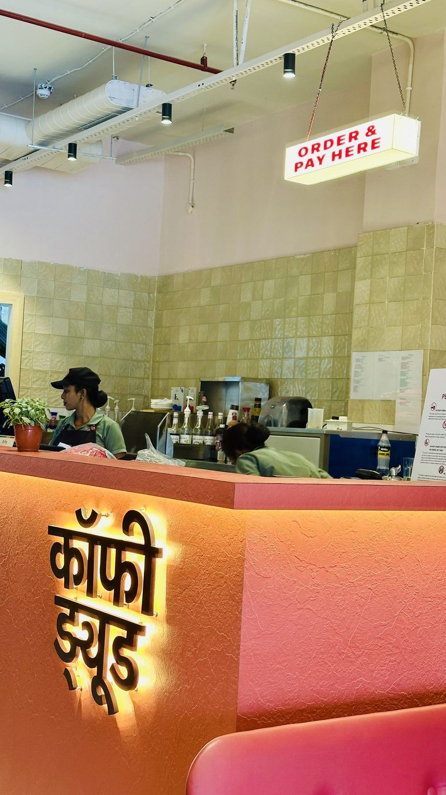 Backlit Hindi lettering on the orange counter at Coffee Dude Gomti Nagar